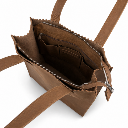 Brown leather handbag with open front pocket on a white background